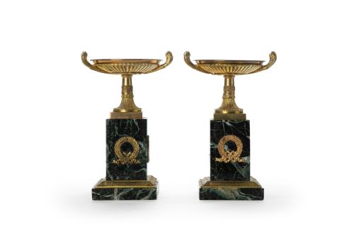 82   -  <p><span class="object_title">Decorativa pareja de copas ornamentales de estilo Carlo X sobre pedestal en bronce dorado y mármol verde veteado con coronas laureadas y remate de copas galonadas, finales S. XIX.</span><br></p>