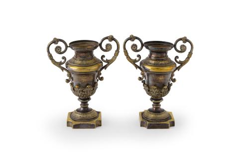 180   -  <p><span class="object_title">Decorativa pareja de copas en metal dorado, con monturas de hojas, base achaflanada y asas de volutas. S. XIX.</span><br></p>