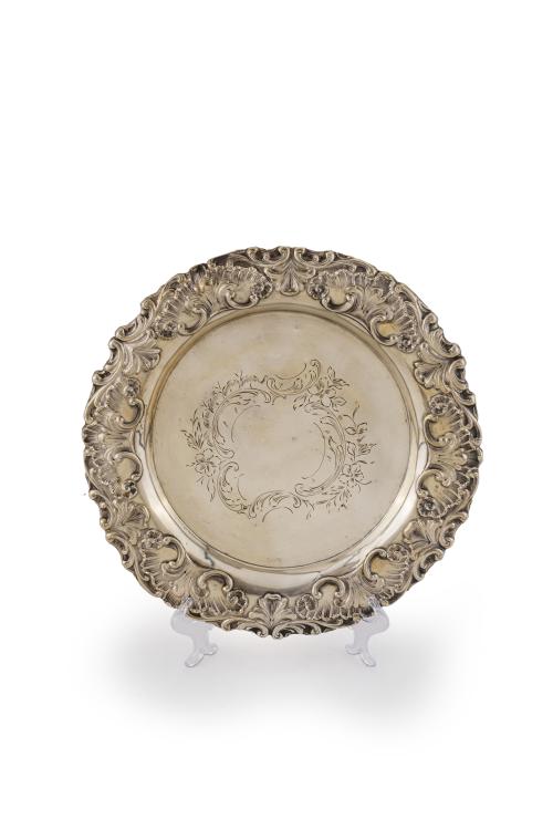 56   -  <p><span class="object_title">Elegante salvilla en plata punzonada portuguesa con marcas de Oporto, ley 833. <br/>Campo grabado con decoración vegetal y floral y alero relevado con rocallas, tornapuntas y hojas.</span><br></p>