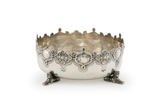 51   -  <p><span class="object_title">Centro de mesa en plata portuguesa punzonada, ley 833, con marcas de Oporto. Decoración grabada y perfil recortado con friso de flores y veneras enmarcado por contarios en relieve. Sobre patas de esfinges. </span><br></p>