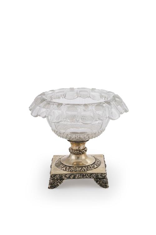 157   -  <p><span class="object_title">Centro en cristal moldeado y tallado a rueda con decoración de punta de diamante y perfil ondulado. Pie cuadrado en plateado con decoración vegetal relevada. </span><br></p>