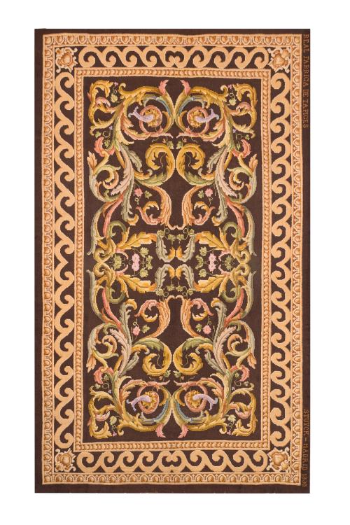 129   -  <p><span class="object_title">Alfombra en lana de nudo español de la Real Fábrica de Tapices, 1930.<br/>Campo decorado con roleos vegetales en tonos rosas, verdes, azules y oro viejo sobre campo marón sobre cenefa oscura. </span><br></p>