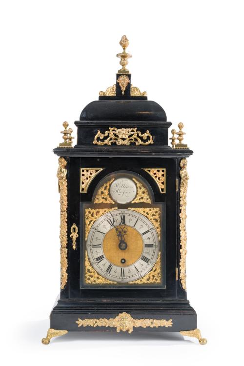 56 - <p><span class="object_title">WILLIAM HOOPER (act. 1881-1941)<br/>Reloj bracket con caja en madera ebonizada y aplicaciones de bronce dorado sobre patas de garra sobre bola y remate de antorcha. Pletina y placas con decoración vegetal relevada. <br/></span><br></p>