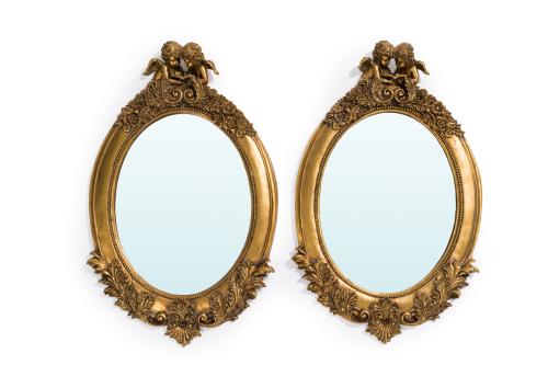 207   -  <p><span class="object_title">Pareja de espejos ovales de pared con marco en madera tallada y dorada con angelitos en el remate y detalles vegetales. Filo de contario de perlas. S. XX.</span><br></p>