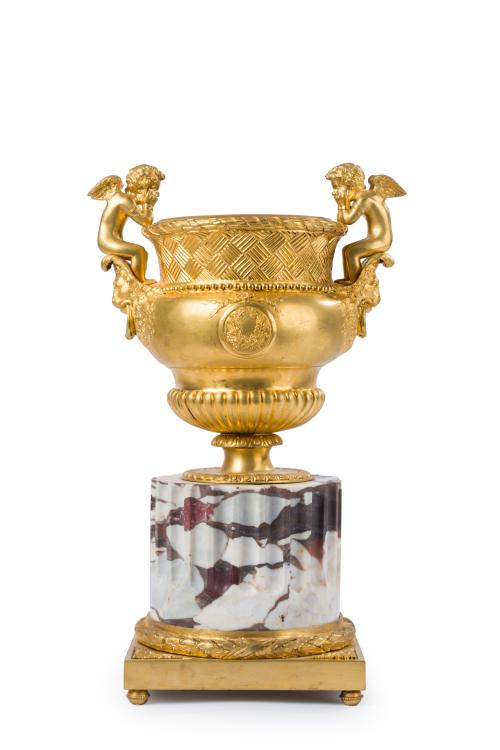 Urna clásica en bronce dorado, asas en forma de angelotes s