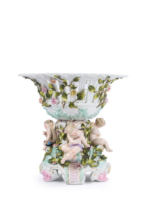 249 - <p><span class="object_title">Centro de mesa en forma de cesta calada en porcelana centroeuropea esmaltada sobre base con cupidos y decoración de guirnaldas florales. Con marcas. </span><br></p>