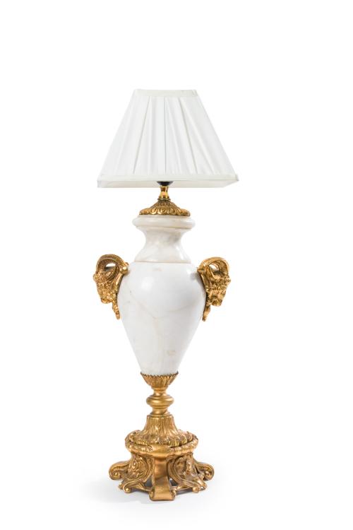 357 - <p><span class="object_title">Lámpara de sobremesa con fuste en forma de jarrón de estilo Luis XVI en mármol blanco y montura en bronce dorado. Asas con cabezas de carnero.</span><br></p>