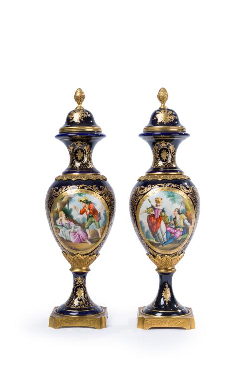 288 - <p><span class="object_title">Pareja de copas de estilo Sévres en porcelana esmaltada en azul cobalto con monturas en bronce dorado. Decoración de escenas galantes en reserva y detalles en dorado.</span><br></p>