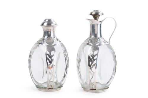 315 - <p><span class="object_title">JOHN HAIG, Escocia, Años 60.<br/>Lote de jarrita y botella para licor en cristal moldeado con embocaduras y monturas decoradas con flores en plata mexicana punzonada. </span><br></p>