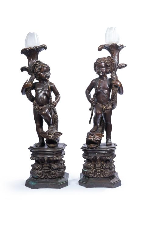 4 - <p><span class="object_title">SIGUIENDO MODELOS DE AUGUSTE MOUREAU. <br/>Pareja de niños torcheros con carcaj en bronce pavonado sobre animales marinos. Sobre bases vegetales. Con tulipas originales de antorchas. Firmados: "Moureau". </span><br></p>