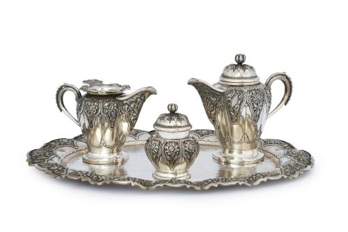 287 - <p><span class="object_title">Juego de té en plata 800, posiblemente balinés. <br/>Formado por: bandeja oval, tetera, jarrita con colador y bote con tapa. Decoración cincelada floral y vegetal en reservas. </span><br></p>