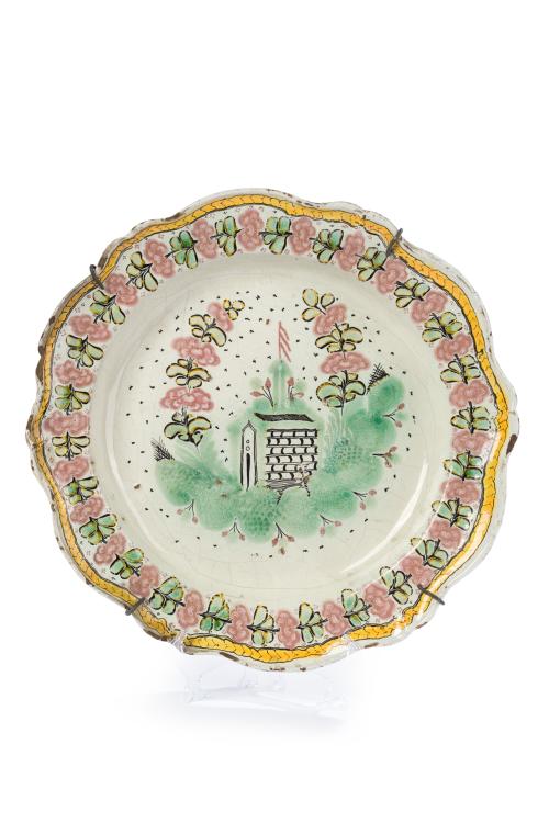 423 - <p><span class="object_title">Plato decorativo en cerámica portuguesa, S. XIX.<br/>Decoración en el campo de paisaje y alero ondulado de flores. Pelos.</span><br></p>