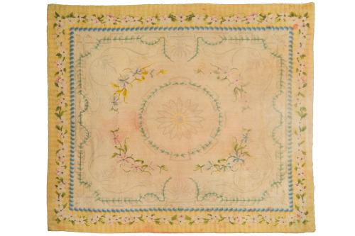 127 - <p><span class="object_title">Alfombra en lana de nudo español de la Real Fábrica de Tapices, 1957.<br/>Diseño savonerie, con florón central en medallón sobre campo beige y cenefa con guirnaldas de flores. Firmada. </span><br></p>