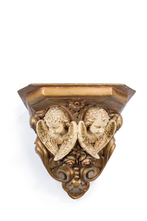 388   -  <p><span class="object_title">Gran ménsula en madera tallada, estucada y pintada con decoración de cabezas de ángeles. Decoración de flores y tornapuntas. Ppios S. XX. </span><br></p>