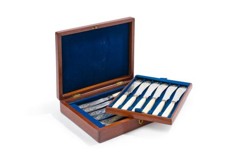 50   -  <p><span class="object_title">MAPPIN & WEBB, Inglaterra, c.1900<br/>Juego de 12 palas de pescado con mangos en hueso y hojas en plateado con decoración vegetal cincelada. En su caja de madera original. </span><br></p>