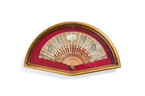 325   -  <p><span class="object_title">Abanico español, c. 1900<br/>Con varillaje en madera tallada y calada con decoración de motivos vegetales y florales, pais en tela con aplicación de lentejuelas y cartela central con figuras mitológicas. <br/>En su abaniquera. </span><br></p>
