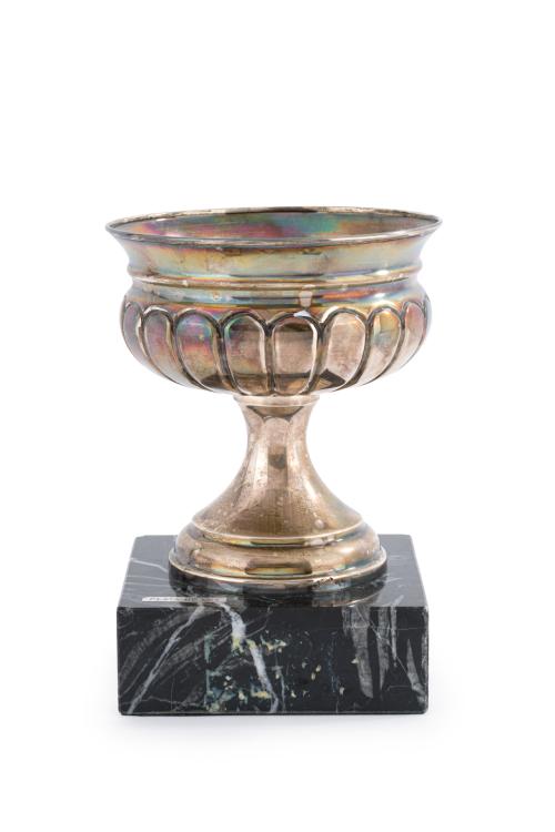 Trofeo en plata española punzonada sobre peana en mármol. 