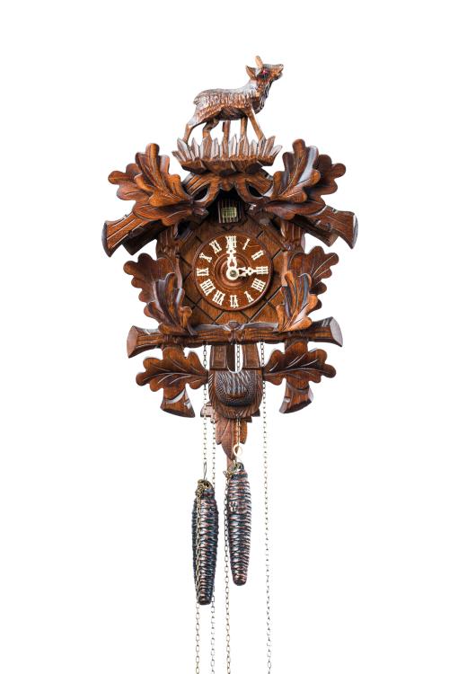 Reloj cuco en madera con remate de animal. 