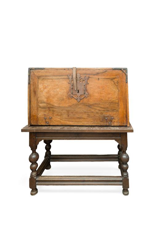 137   -  <p><span class="object_title">Bargueño castellano, S. XVII y posterior. <br/>En madera de nogal, con decoración de taracea geométrica y fileteados en maderas contrastadas. <br/>De estructura prismática, frente con tapa fronatal abatible, decorada al exterior con motivos geométricos y herrajes y cerraduras en hierro forjado. Al interior muestra interior compartimentado con gavetas de distintos tamaños y puerta cental igualmente decorados con motivos geométricos. <br/>Sobre mesa de época posterior con patas torneadas unidas por chambrana. <br/></span><br></p>