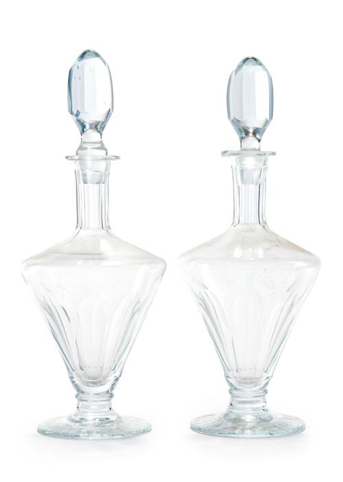 581   -  <p><span class="object_title">Pareja de licoreras en vidrio incoloro facetado y tallado. Cuerpo periforme, cuello gallonado y tapones facetados. Base con decoracción radial. Probablemente Bohemia, mediados siglo XX</span><br></p>