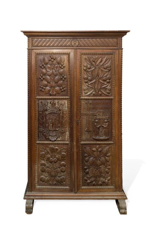 582   -  <p><span class="object_title">Armario castellano neorrenacimiento, s. XX<br/>En madera de castaño. De doble puerta, frente con 6 paneles tallados, uno con escudo del águila imperial (Águila de San Juan), otro presenta la Cruz de la Victoria sostenida por dos ángeles (símbolo heráldico del Principado de Asturias) y otros con profusa decoración de cardinas, flores y frutos.  En friso superior medallón con el yugo y haz de flechas (emblema de los Reyes Catlólicos). <br/>Al interior barra y distintos cajones en parte inferior. <br/></span><br></p>
