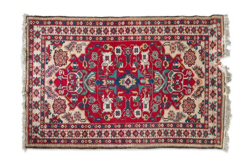 21   -  <p><span class="object_title">Alfombra persa en lana anudada a mano, s. XX<br/>Campo en tono rojo con composición geométrica estilizada, con medallón central alargado en tonos azul, rojo y crudo. Cenefa perimetral con motivos geométricos y florales. </span><br></p>
